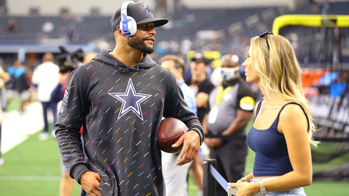 Dak Prescott #4 of the Dallas Cowboys talks with Natalie Buffett on the field before the game against the Carolina Panthers at AT&amp;amp;T Stadium on October 03, 2021 in Arlington, Texas.