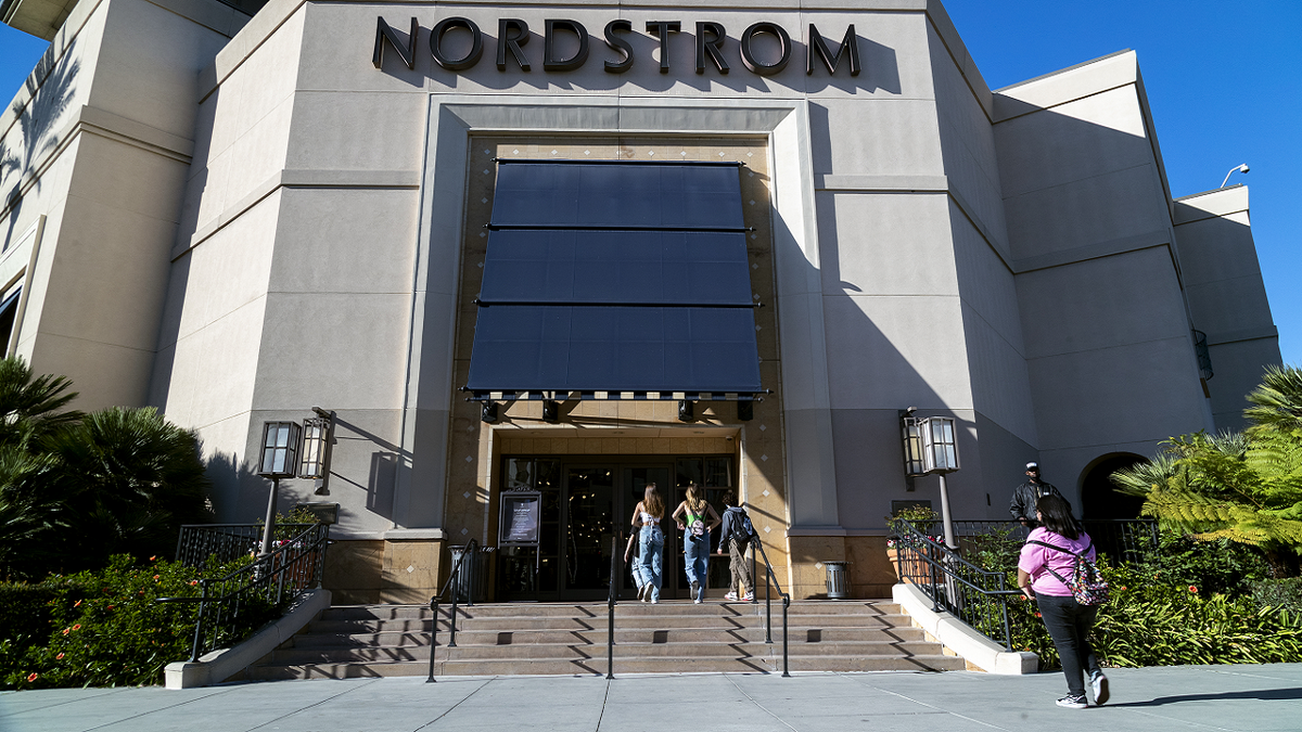 A security guard patrols the front entrance of the Nordstrom store at The Grove shopping center in Los Angeles on Nov. 23 after an organized group of thieves attempted a smash-and-grab robbery. 