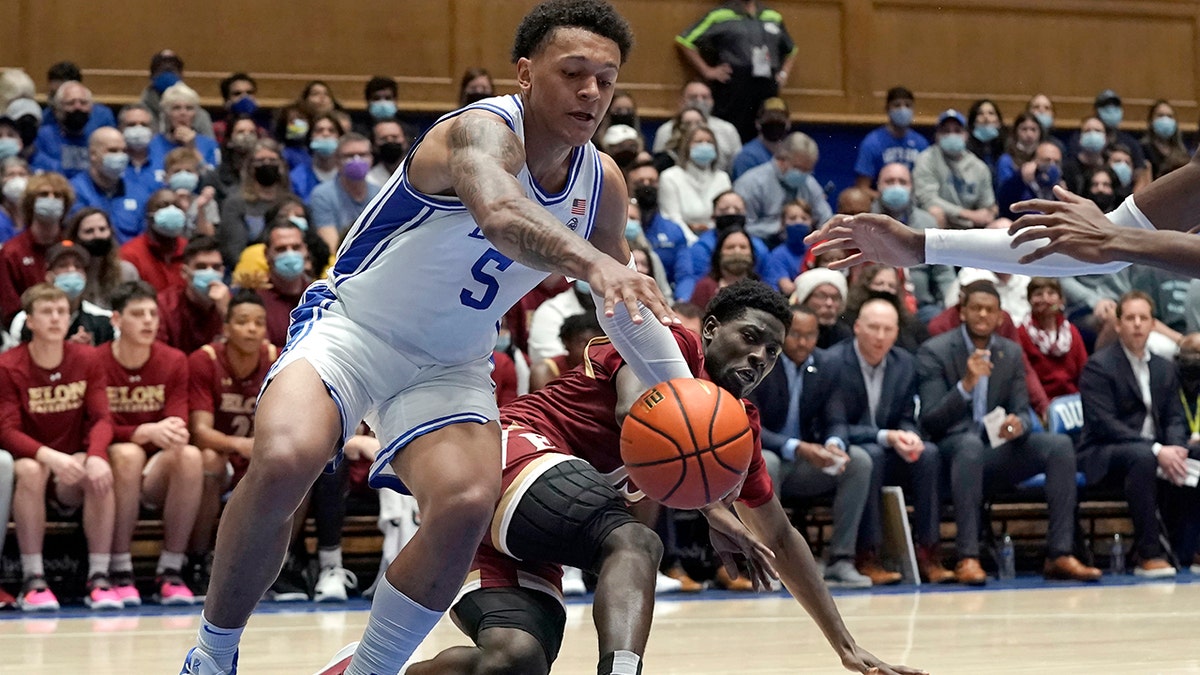 Duke forward Paolo Banchero (5) and Elon guard Jerald Gillens-Butler chase the ball during the first half of an NCAA college basketball game in Durham, N.C., Saturday, Dec. 18, 2021. 