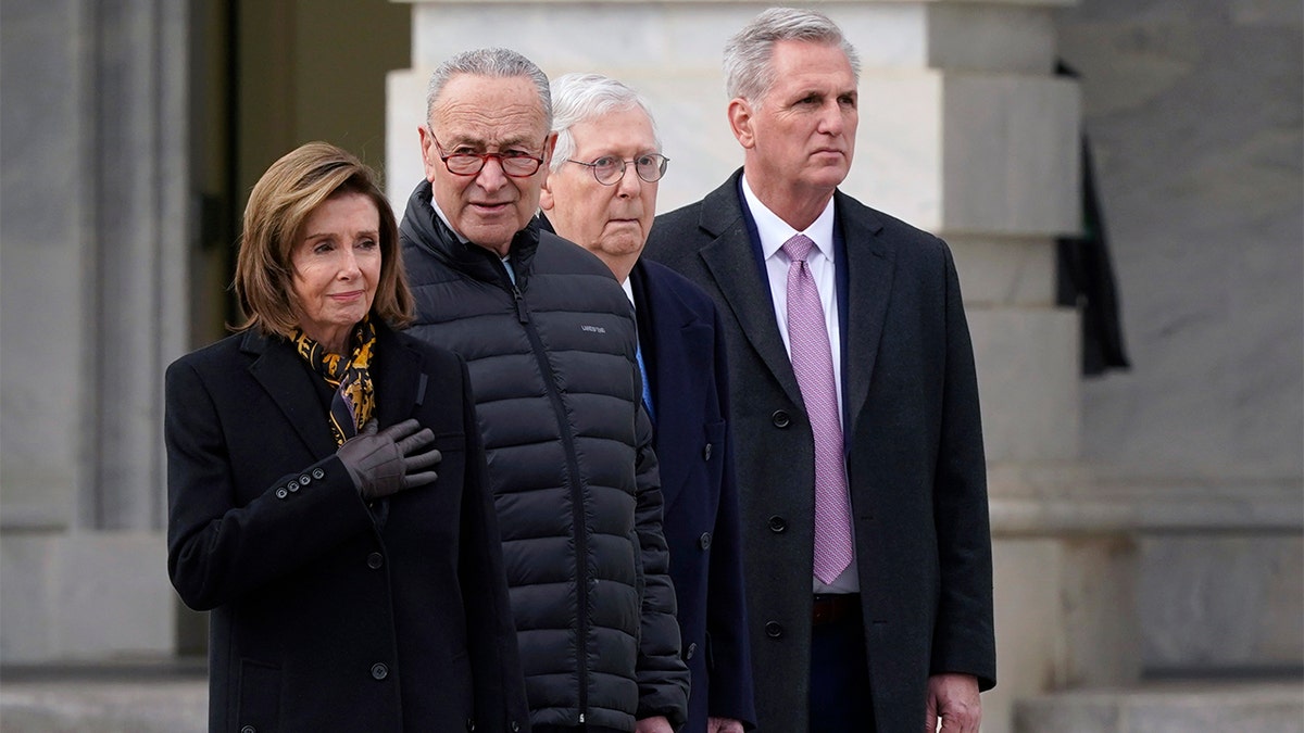 From left, House Speaker Nancy Pelosi of Calif., Senate Majority Leader Chuck Schumer of N.Y., Senate Minority Leader Mitch McConnell of Ky., and House Minority Leader Kevin McCarthy of Calif., watch as the casket of former Sen. Bob Dole, R-Kan., is carried down the East steps of Capitol Hill in Washington, Friday, Dec. 10, 2021, where Dole was lying in state. (AP Photo/Susan Walsh)