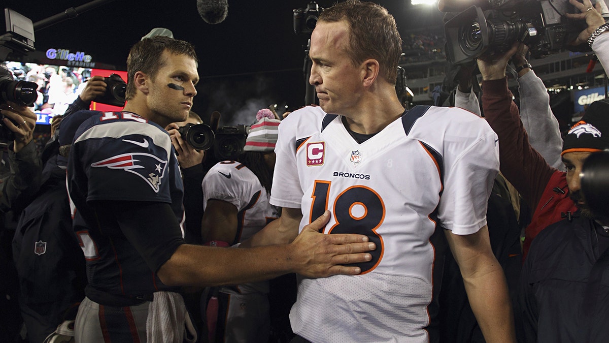 Denver Broncos QB Peyton Manning (18) with New England Patriots quarterback Tom Brady after a game at Gillette Stadium in Foxborough, Massachusetts.