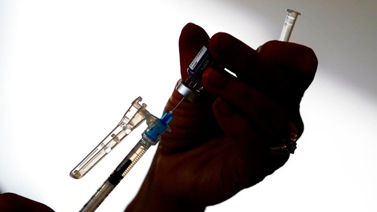 A syringe is prepared with the Pfizer COVID-19 vaccine at a clinic in the Norristown Public Health Center in Norristown, Pa., Tuesday, Dec. 7, 2021. (AP Photo/Matt Rourke)