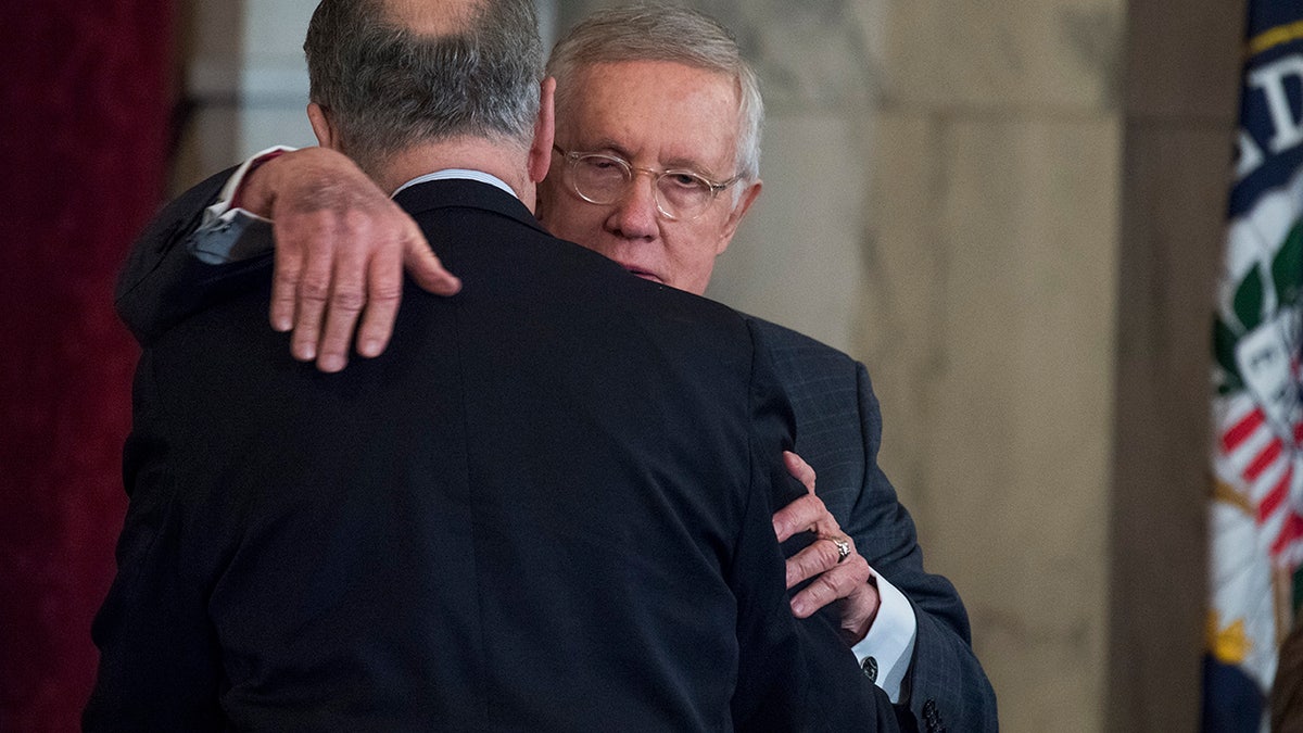 UNITED STATES - DECEMBER 08: Retiring Senate Minority Leader Harry Reid, D-Nev., right, hugs incoming Senate Minority Leader Charles Schumer, D-N.Y., during Reid's portrait unveiling ceremony in Russell Building's Kennedy Caucus Room, December 08, 2016.