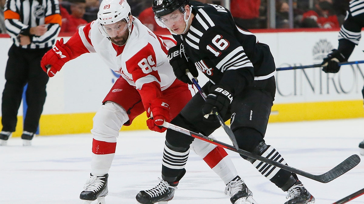 Detroit Red Wings center Sam Gagner (89) tries to steal the puck from New Jersey Devils left wing Jimmy Vesey (16) during the third period of an NHL hockey game Saturday, Dec. 18, 2021, in Detroit.