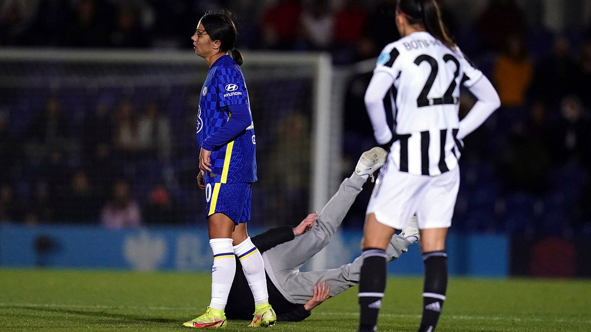 A pitch invader is grounded courtesy of Chelsea's Sam Kerr during the Women's Champions League, Group A match between Chelsea and Juventus at Kingsmeadow, London, Wednesday, Dec. 8, 2021. 