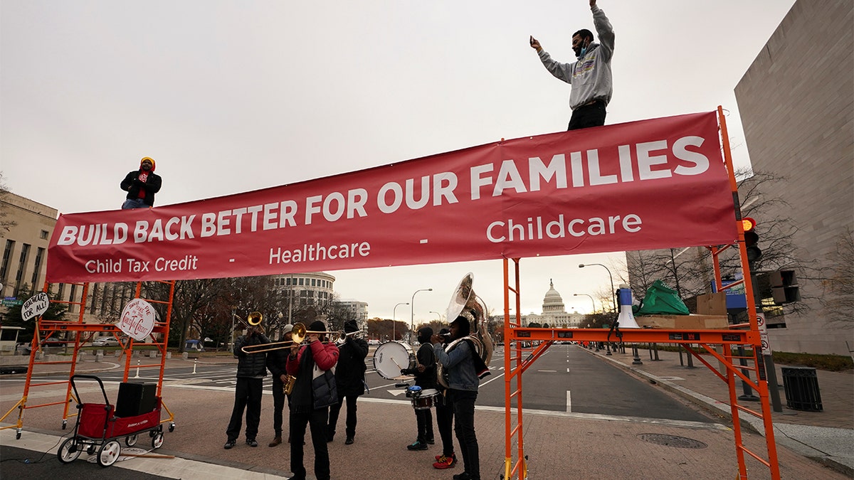 An activist dances to a band atop a street blockade near the U.S. Capitol in Washington, Dec. 7, 2021.