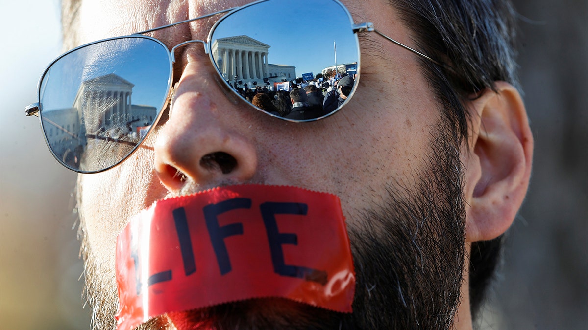 An anti-abortion activist attends a protest outside the Supreme Court building ahead of arguments in the Mississippi abortion rights case Dobbs v. Jackson Women's Health, in Washington, Dec. 1, 2021. 