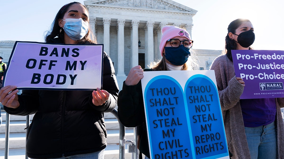 Caroline McDonald, left, a student at Georgetown University, Lauren Morrissey of Catholics for Choice and Pamela Huber of Washington join an abortion-rights rally outside the Supreme Court, Monday, Nov. 1, 2021, in Washington. 