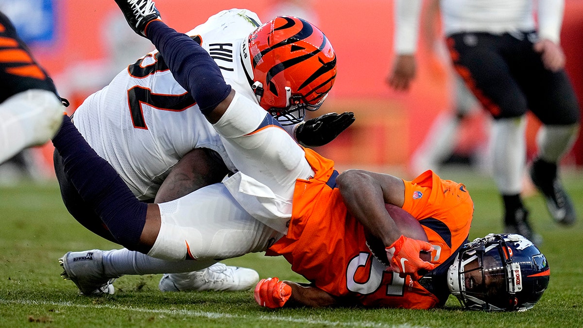 Denver Broncos quarterback Teddy Bridgewater (5) is hit by Cincinnati Bengals defensive end B.J. Hill during the second half of an NFL football game, Sunday, Dec. 19, 2021, in Denver. Bridgwater left the game after being injured on the play.