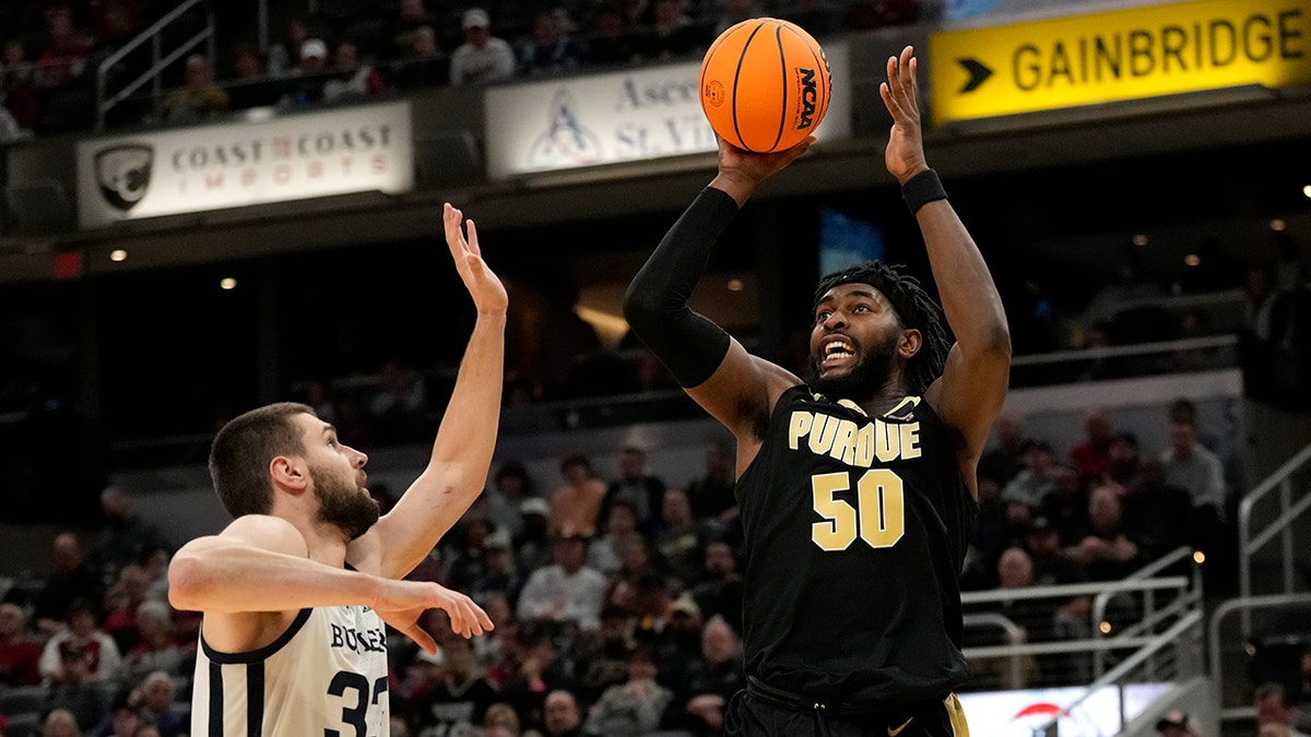 Purdue forward Trevion Williams (50) shoots over Butler forward Bryce Golden, left, during the second half of an NCAA college basketball game, Saturday, Dec. 18, 2021, in Indianapolis.