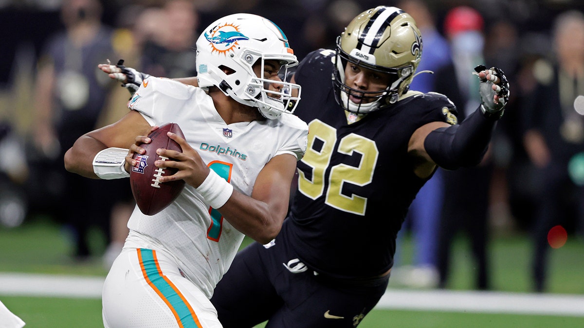 Miami Dolphins quarterback Tua Tagovailoa (1) is pressured by New Orleans Saints defensive end Marcus Davenport (92) during the second half of an NFL football game Monday, Dec. 27, 2021, in New Orleans.
