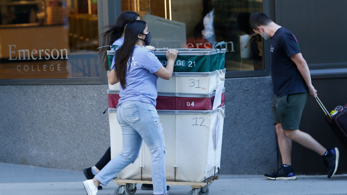 Move-in assistants push empty carts down Boylston Street as students return to Emerson College's campus in Boston on Aug. 27, 2020.