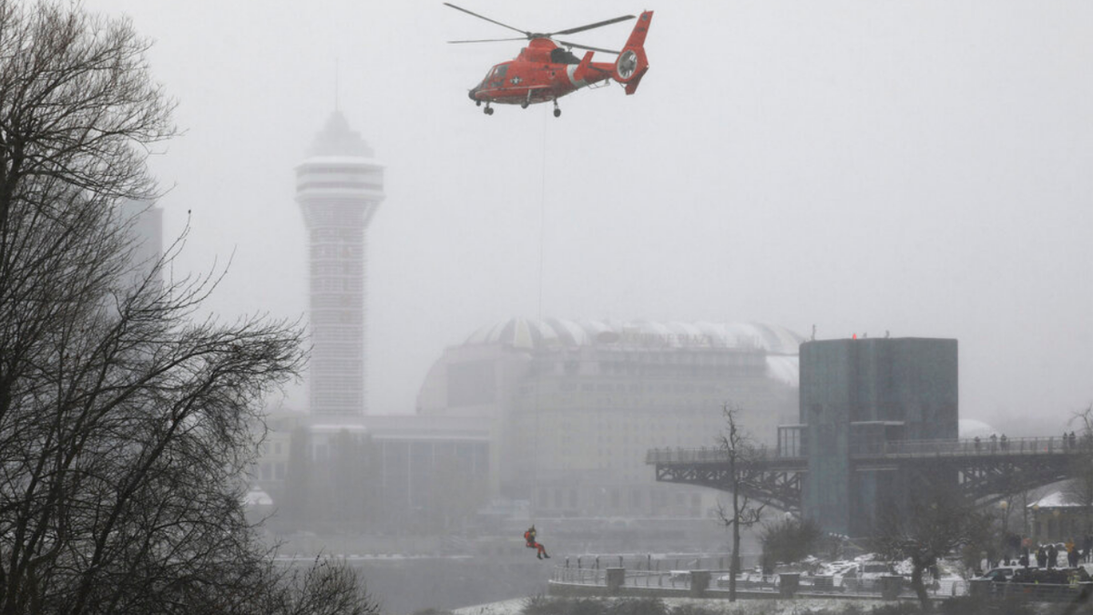 A U.S. Coast Guard rescue diver is lowered toward the vehicle lodged in the water at the brink of Niagara Falls, Wednesday, Dec. 8, 2021.