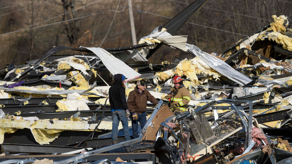 Emergency workers search through what is left of the Mayfield Consumer Products Candle Factory after it was destroyed by a tornado in Mayfield, Kentucky