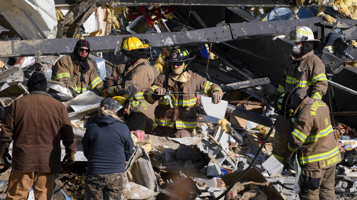 Emergency workers search through what is left of the Mayfield Consumer Products Candle Factory after it was destroyed by a tornado in Mayfield, Kentucky, on December 11, 2021. . (Photo by John Amis / AFP) (Photo by JOHN AMIS/AFP via Getty Images)