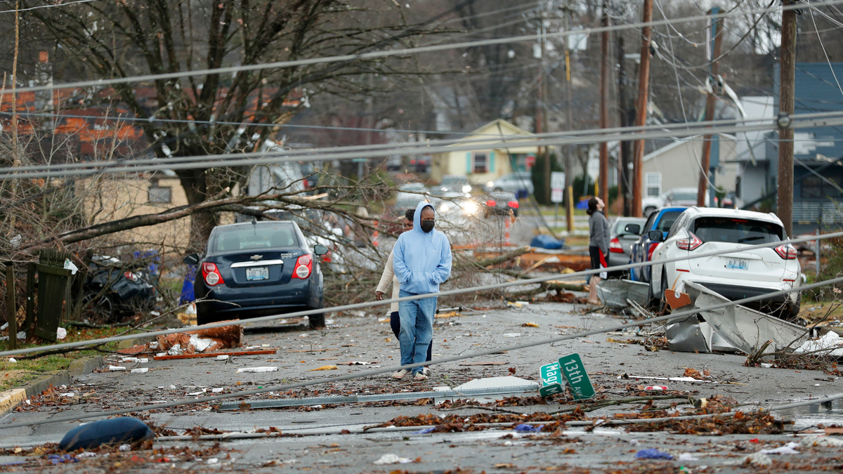 Bowling Green, Kentucky, residents look at the damage following a tornado that struck the area on December 11, 2021. - Tornadoes ripped through five US states overnight, leaving more than 70 people dead Saturday in Kentucky and causing multiple fatalities at an Amazon warehouse in Illinois that suffered "catastrophic damage" with around 100 people trapped inside. The western Kentucky town of Mayfield was "ground zero" of the storm -- a scene of "massive devastation," one official said. (Photo by Gunnar Word / AFP) (Photo by GUNNAR WORD/AFP via Getty Images)
