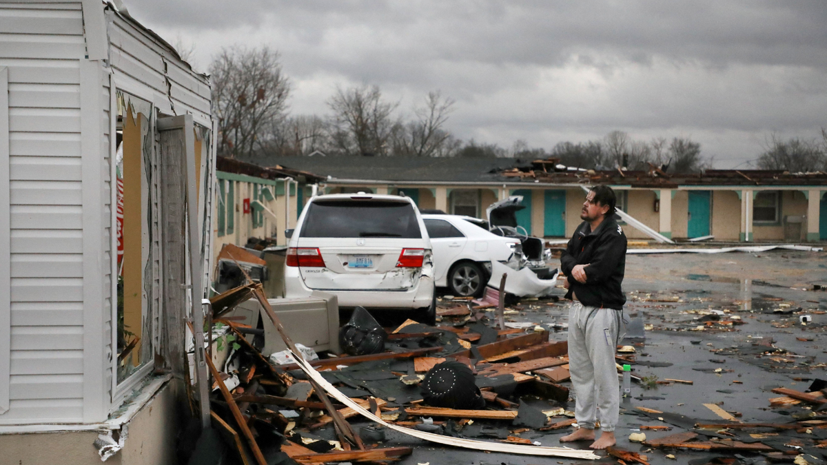 TOPSHOT - A resident of the The Cardinal Inn in Bowling Green, Kentucky, looks at the damages done after a tornado touched down on December 11, 2021. - Tornadoes ripped through five US states overnight, leaving more than 70 people dead Saturday in Kentucky and causing multiple fatalities at an Amazon warehouse in Illinois that suffered "catastrophic damage" with around 100 people trapped inside. The western Kentucky town of Mayfield was "ground zero" of the storm -- a scene of "massive devastation," one official said. (Photo by Gunnar WORD / AFP) (Photo by GUNNAR WORD/AFP via Getty Images)