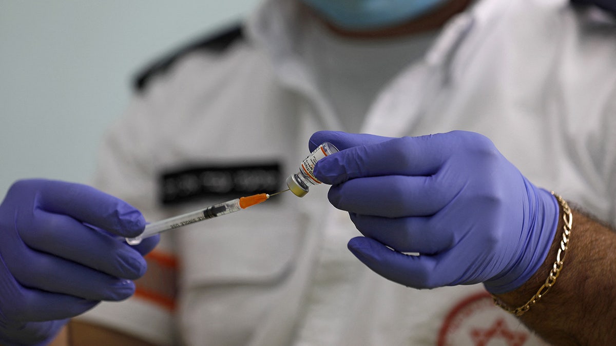 health worker prepares vaccine shot
