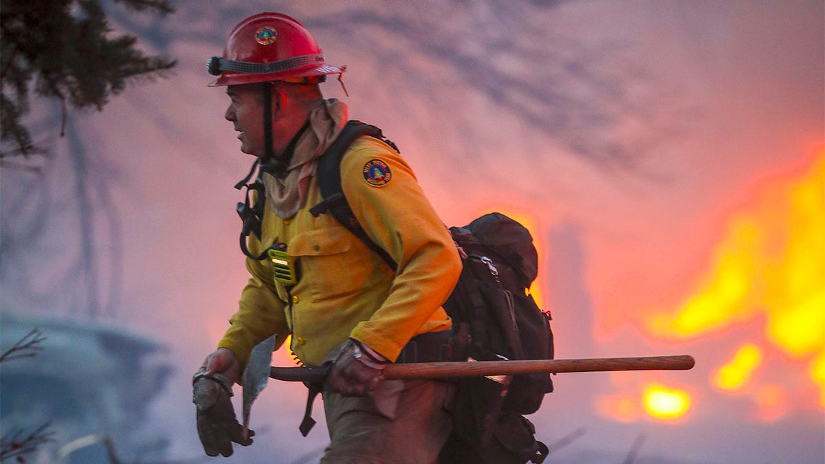 A wildland firefighter fights a fast moving wildfire that swept through the area in the Centennial Heights neighborhood on December 30, 2021 of Louisville, Colorado.