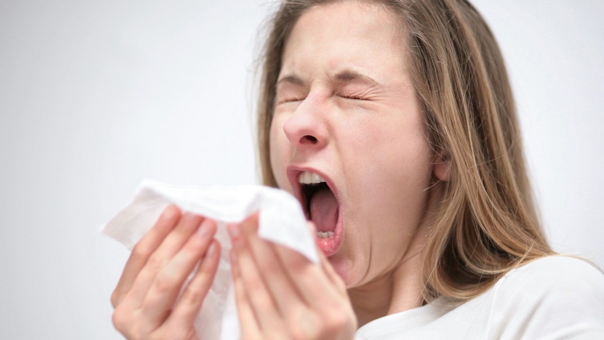 A woman sneezes 