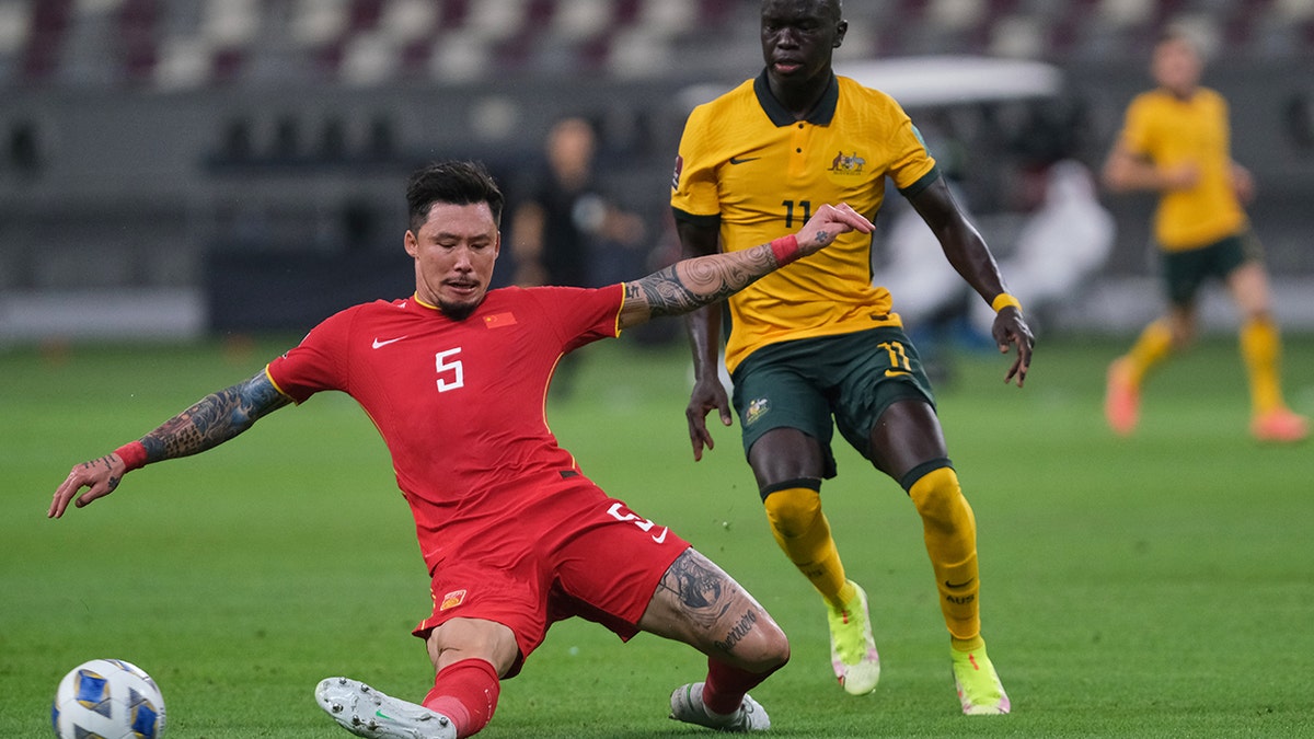 Zhang Linpeng tackles Awer Mabil during Australia v. China PR - 2022 FIFA World Cup Qualifier at Khalifa International Stadium on Sept. 2, 2021, in Doha, Qatar.