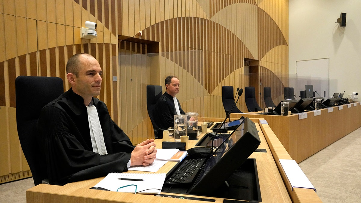 Public prosecutors Ward Ferdinandusse, left, and Thijs Berger wait for the start of the ongoing trial and criminal proceedings regarding the downing of Malaysia Airlines flight MH17, at the high security court at Schiphol airport, near Amsterdam, Netherlands, Monday Dec. 20, 2021.