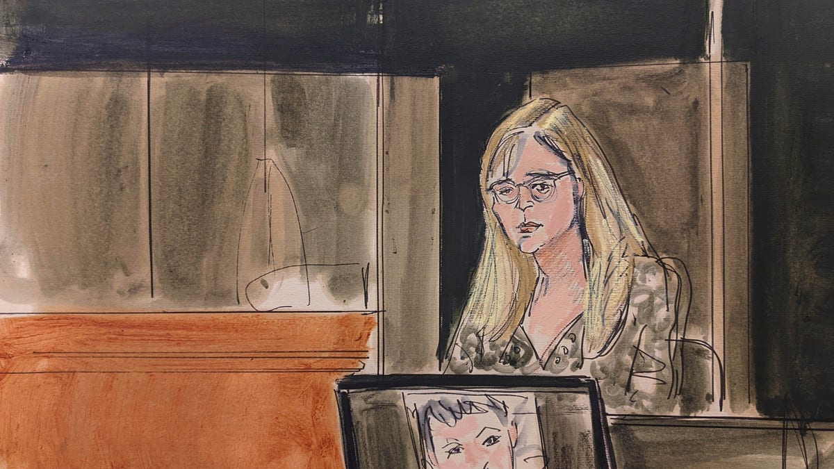 In this courtroom sketch, Annie Farmer testifies on the witness stand during the Ghislaine Maxwell sex abuse trial, Friday, Dec. 10, 2021, in New York. A photo of Maxwell appears on a screen at foreground.(Elizabeth Williams via AP)