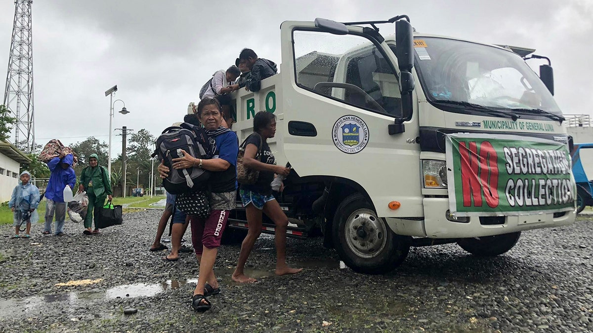 Evacuees arrive at the Siargao Sports Complex in Dapa town, Siargao island, Surigao del Norte province, southern Philippines on Thursday, Dec. 16, 2021. 
