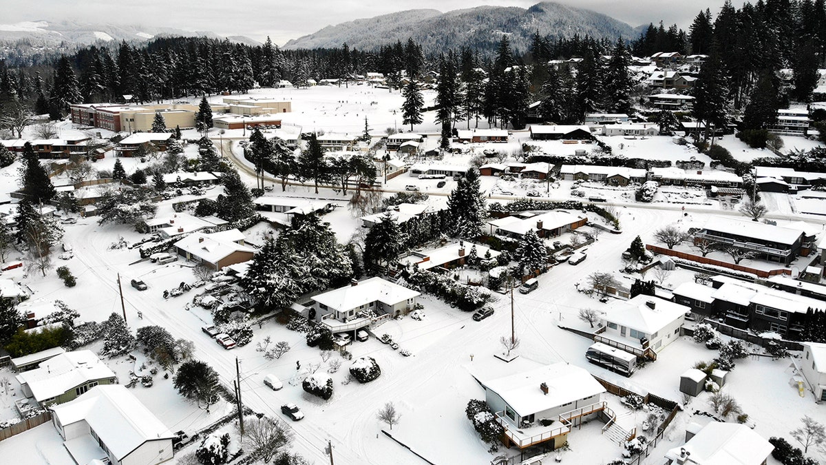 In this photo taken from a drone, snow covers streets, sidewalks and homes where nearly a foot of snow fell over the weekend, Monday, Dec. 27, 2021, in a neighborhood in Bellingham, Washington.