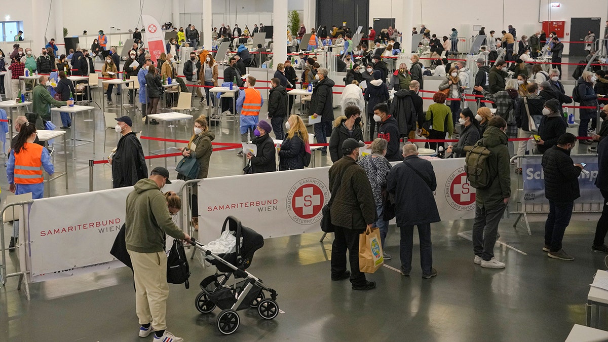 People wait in lines to register for COVID-19 vaccination on the second day of a national lockdown to combat soaring coronavirus infections, in Vienna, Austria, Nov. 23, 2021. 