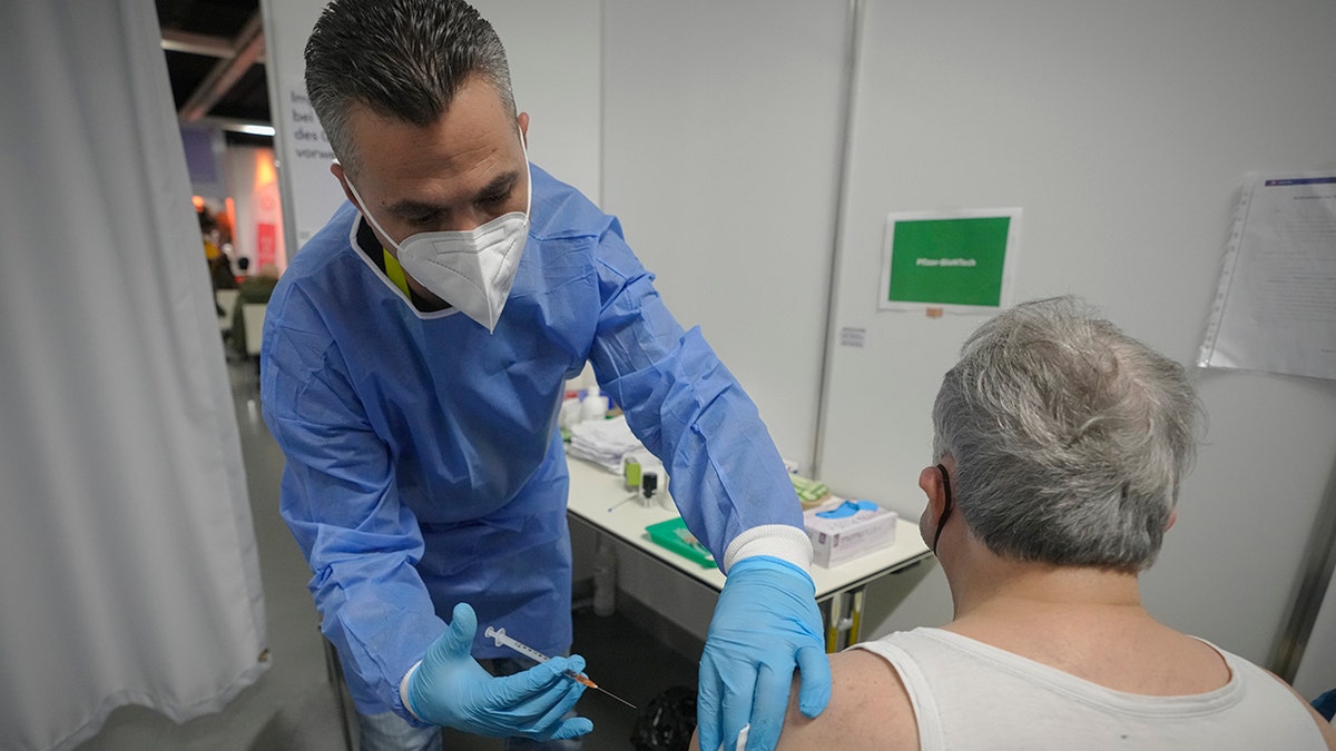 A man receives a COVID-19 vaccine on the second day of a national lockdown to combat soaring coronavirus infections, in Vienna, Austria, Nov. 23, 2021. 
