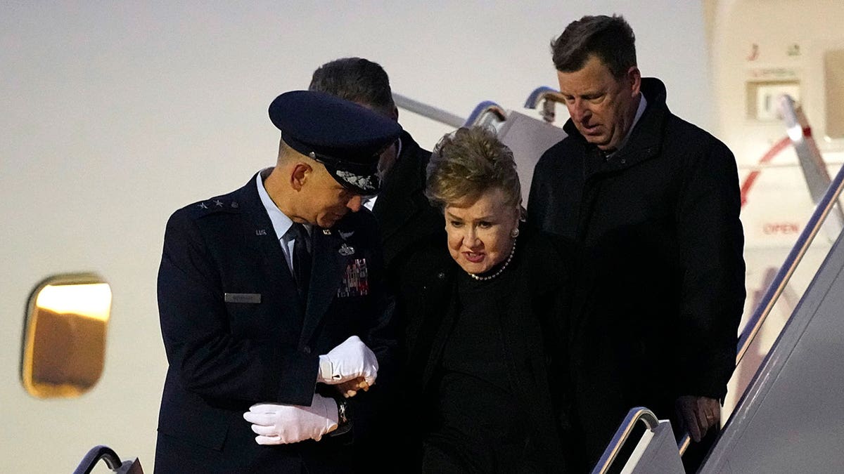 Elizabeth Dole is helped down the boarding stairs after the plane carrying her husband, former Sen. Bob Dole, R-Kan., arrived at the airport in Salina, Kan., Friday, Dec. 10, 2021. 
