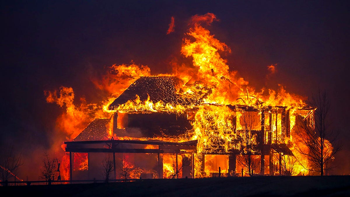 A home burns after a fast moving wildfire swept through the area in the Centennial Heights neighborhood of Louisville, Colorado on December 30, 2021.