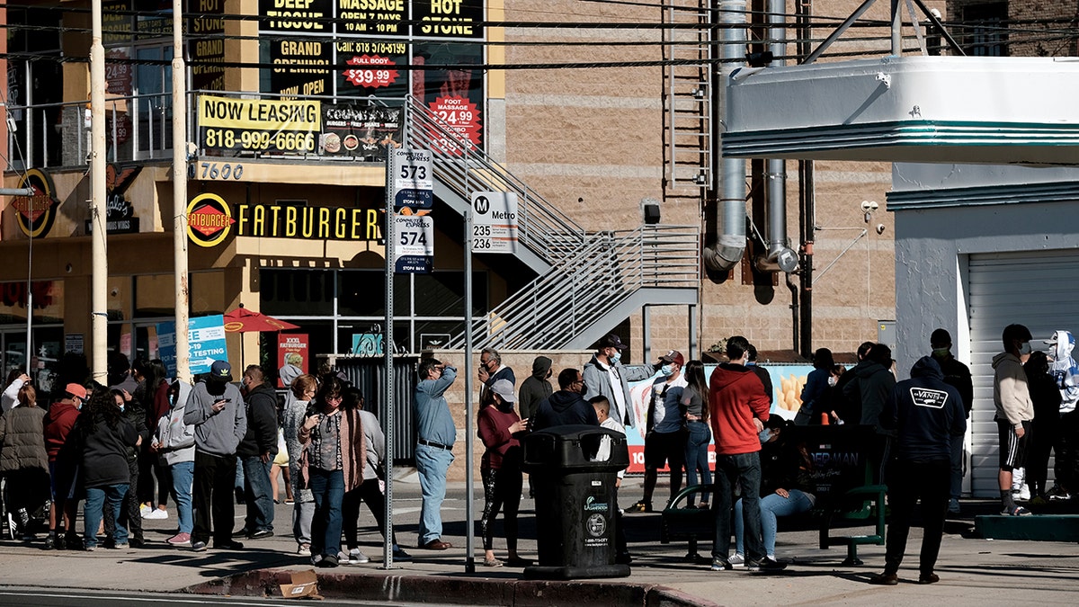 People line up for a free COVID-19 rapid test at a gas station in the Reseda section of Los Angeles on Sunday, Dec. 26, 2021, as California braces for a post-holiday virus surge. 