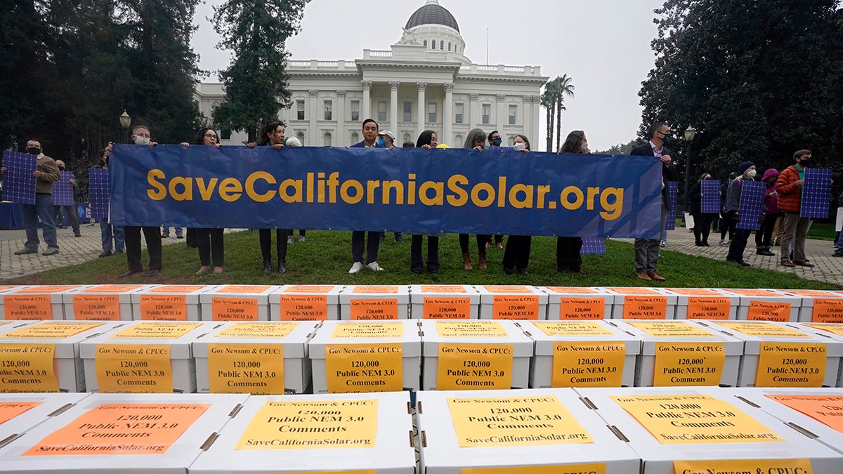Boxes of petitions against proposed reforms that solar energy advocates claim would handicap the rooftop solar market are displayed before they are taken to the governor's office during a rally at the Capitol in Sacramento, California, Wednesday, Dec. 8, 2021.