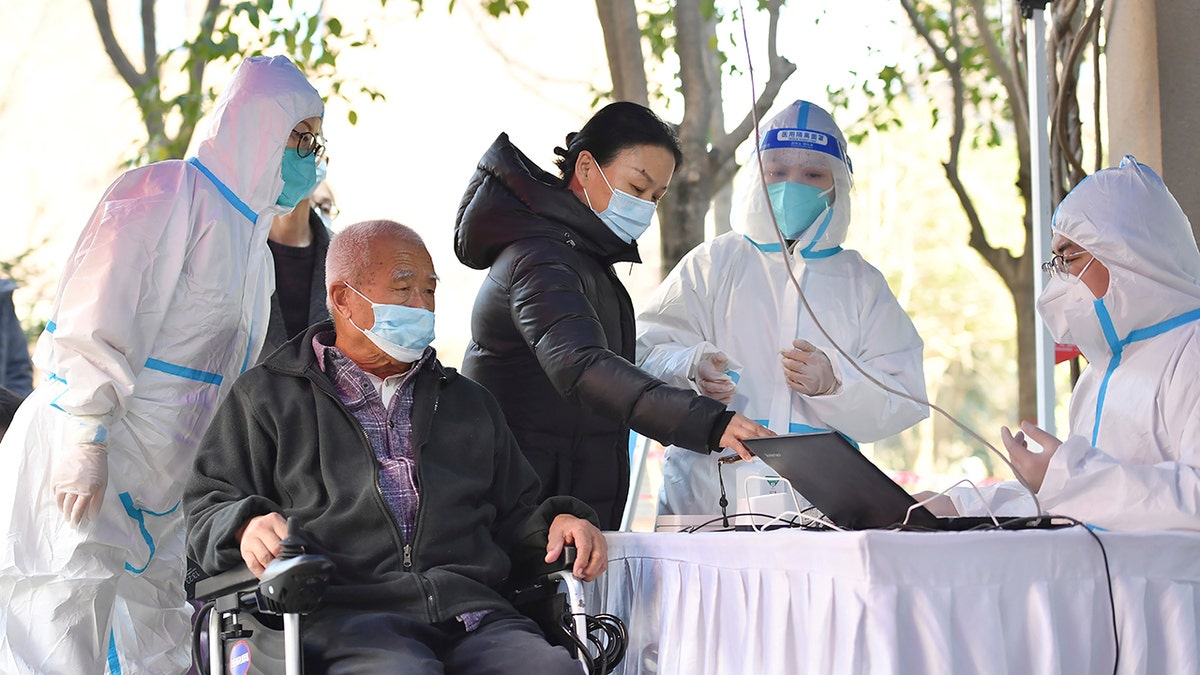 In this photo released by China's Xinhua News Agency, people register for tests at a COVID-19 testing site in Xi'an in northwestern China's Shaanxi Province, Tuesday, Dec. 21, 2021.