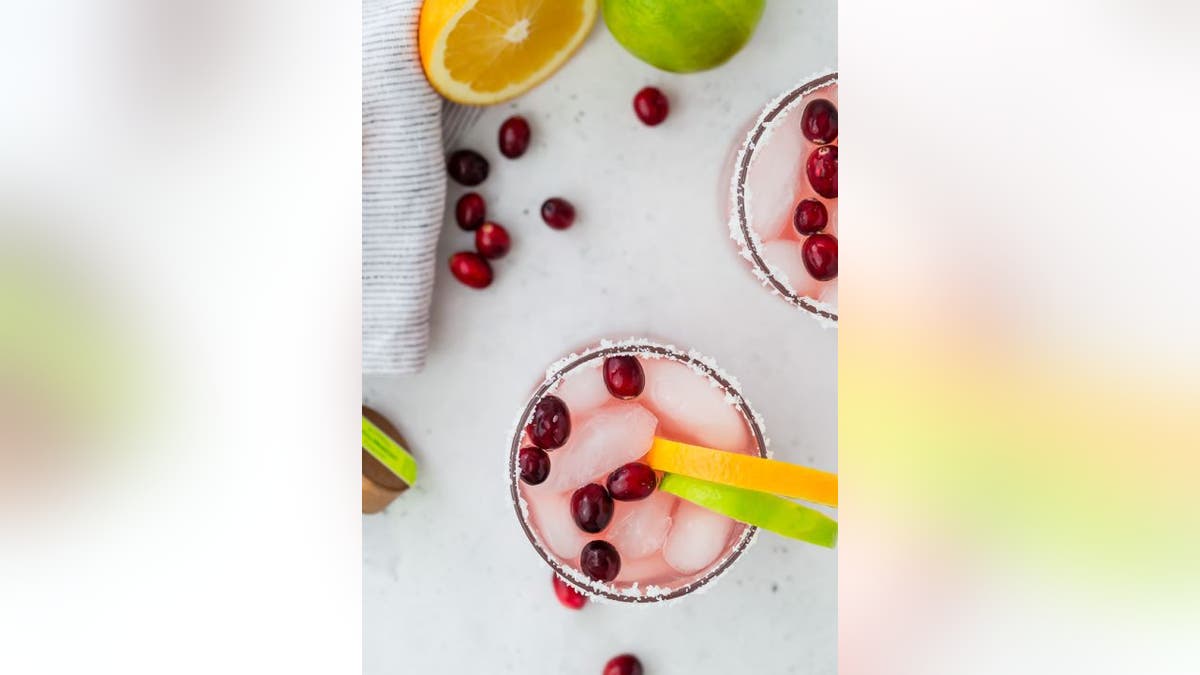 This holiday margarita includes fresh cranberries and orange or lime wedges for garnish.