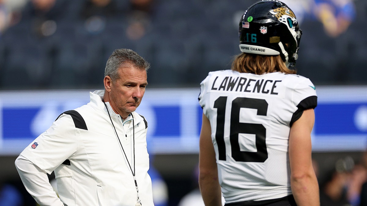 INGLEWOOD, CALIFORNIA - DECEMBER 05: Head coach Urban Meyer of the Jacksonville Jaguars and Trevor Lawrence #16 during warm up before the game against the Los Angeles Rams at SoFi Stadium on December 05, 2021 in Inglewood, California.
