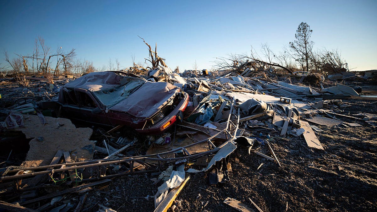 A car sits on top of the rubble of a destroyed house after a tornado in Dawson Springs, Ky., Sunday, Dec. 12, 2021.  A monstrous tornado, carving a track that could rival the longest on record, ripped across the middle of the U.S. on Friday. (AP Photo/Michael Clubb)
