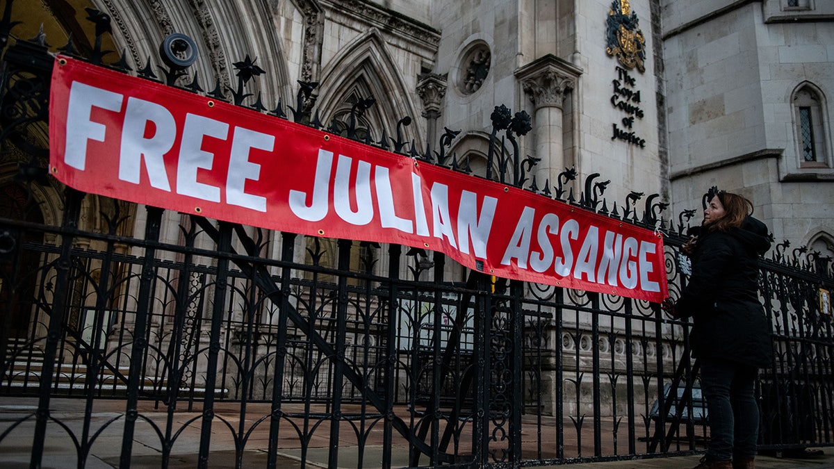A supporter of Julian Assange hangs a banner outside the Royal Courts of Justice on December 10, 2021 in London, England. (Photo by Chris J Ratcliffe/Getty Images)