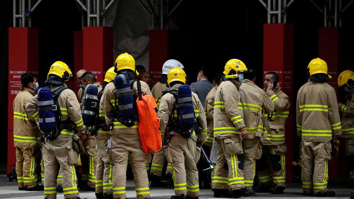 Firefighters stand outside the World Trade Centre in Hong Kong's popular Causeway Bay shopping district on Wednesday, Dec. 15, 2021.