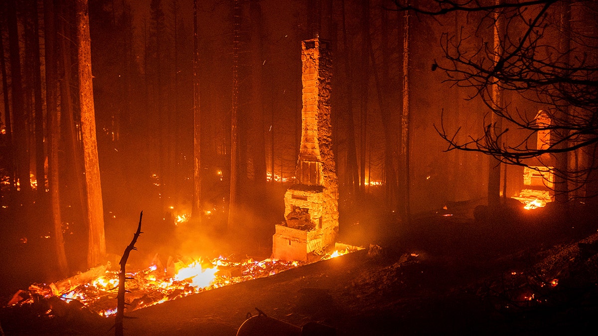 Seen in a long camera exposure, chimneys stand at residences leveled by the Caldor Fire along Highway 50 on Aug. 29, 2021, in Eldorado National Forest, California.