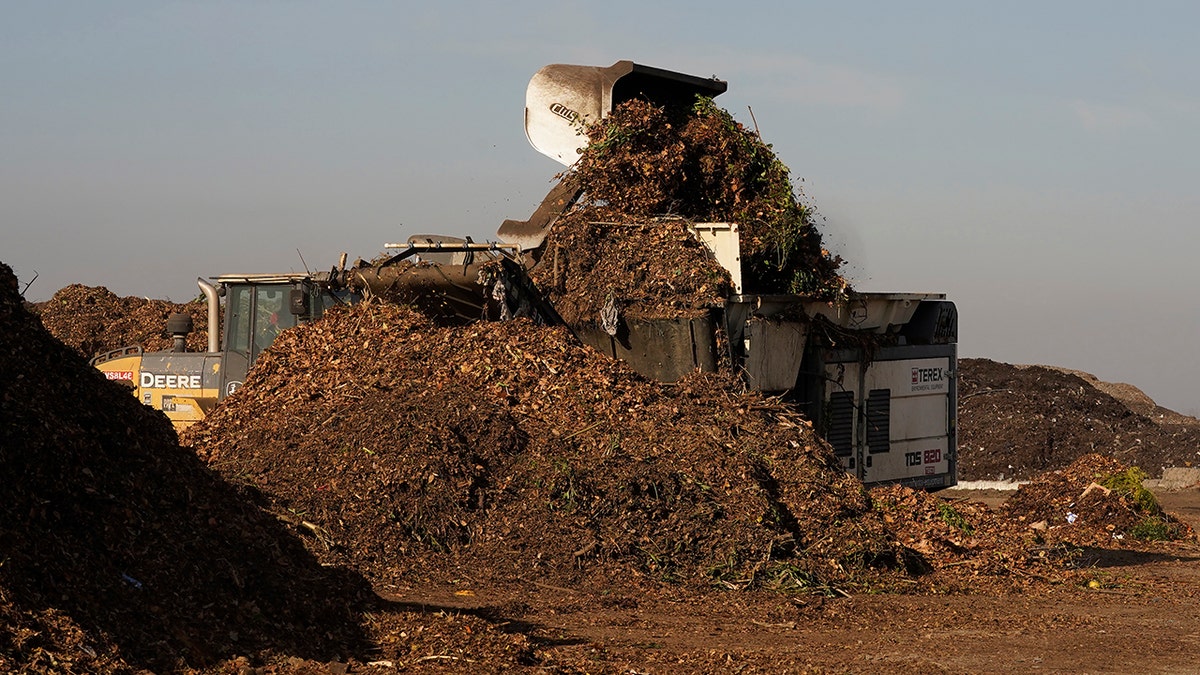 Garden waste is dumped into a grinding machine with other compostable items at the Anaerobic Composter Facility at the Yolo County Central Landfill in Woodland, California, Tuesday, Nov. 30, 2021.