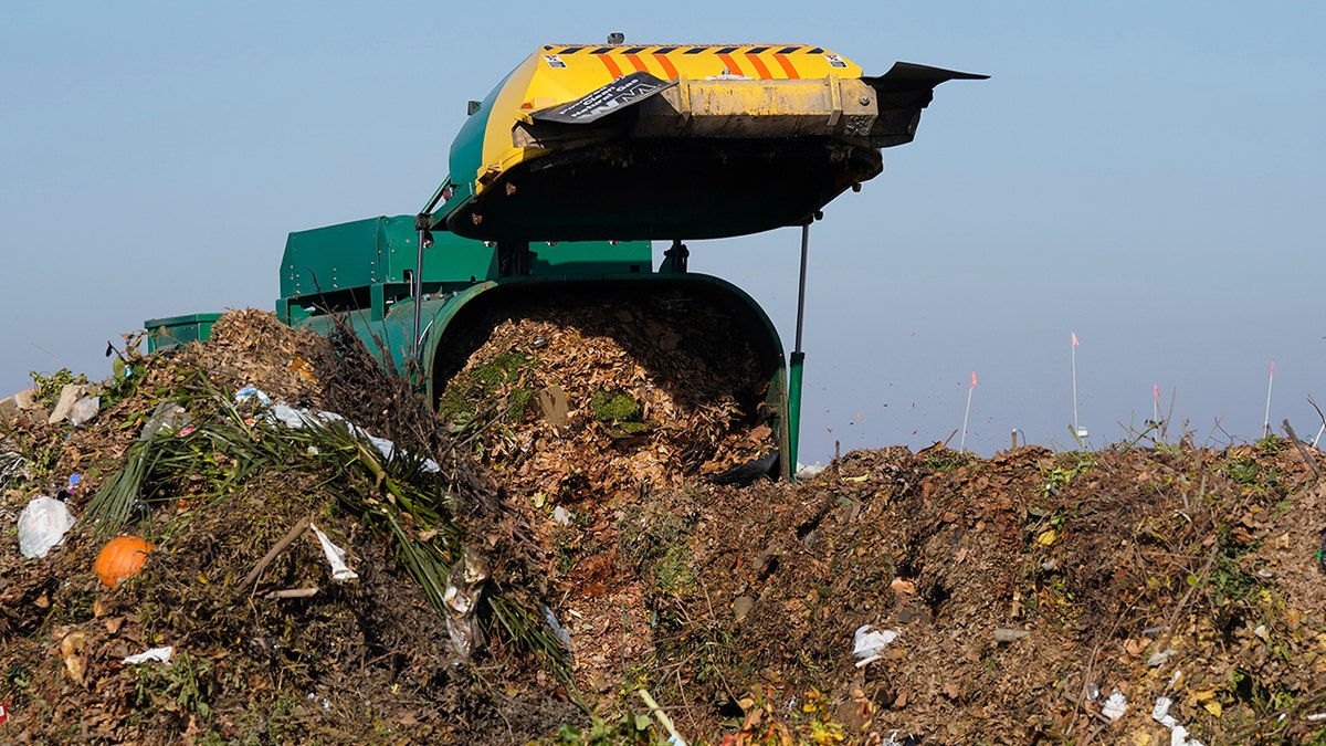 A truck unloads organic waste to be used for composting at the Anaerobic Composter Facility in Woodland, California, Tuesday, Nov. 30, 2021. 