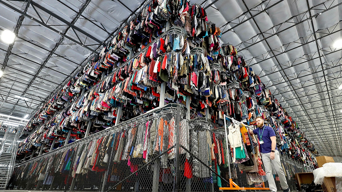 Thousands of garments are stored on a three-tiered conveyor system at the ThredUp sorting facility in Phoenix on March 12, 2019.