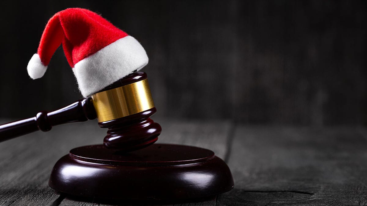 Santa Claus hat on Judge Gavel on wooden rustic background