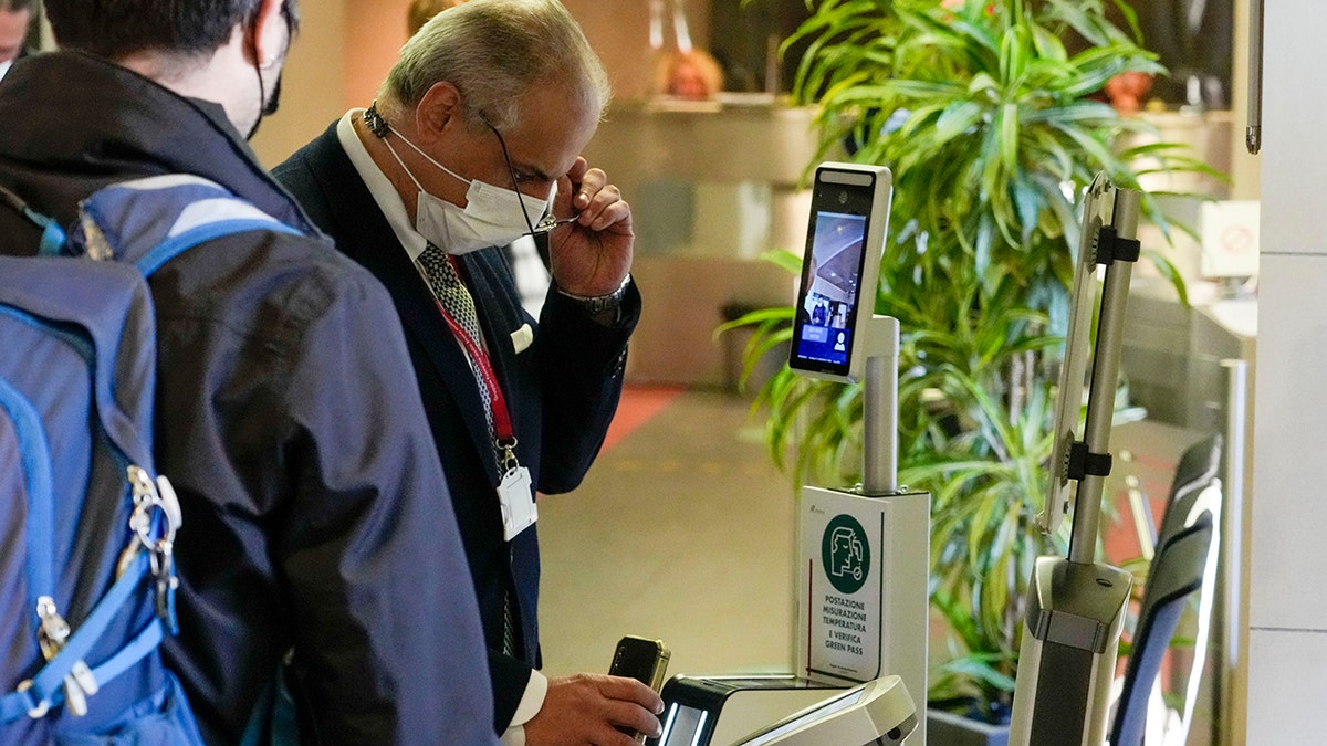 An employee has his certification checked as Italy's new "Green Pass" vaccination requirement for employees to enter their offices became mandatory, at the Trenitalia, Italian train company offices, in Rome, on Oct. 15, 2021. 