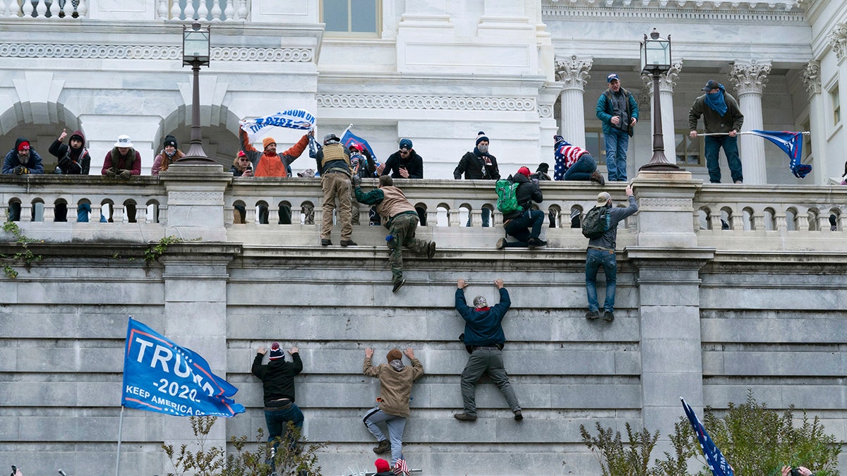Violent insurrectionists loyal to then-President Trump climb the west wall of the the U.S. Capitol in Washington, Jan. 6, 2021. 