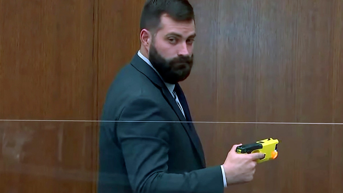 Sam McGinnis holds the Taser of former police officer Kim Potter