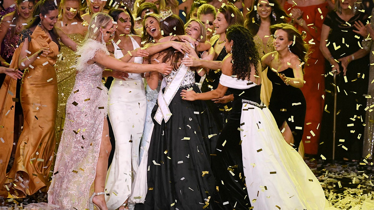 Miss Alaska Emma Broyles is surrounded by a group hug after being crowned Miss America, Thursday, Dec. 16, 2021, at Mohegan Sun.
